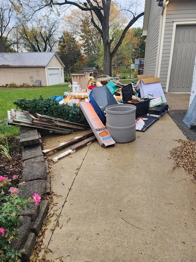 Dumpster being loaded with debris for 12 Yard Dumpster Rental in Genesee